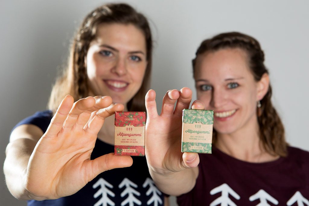 Die Gründerinnen von Alpengummi Sandra Falkner und Claudia Bergero halten jeweils eine Packung Alpengummi ins Bild.